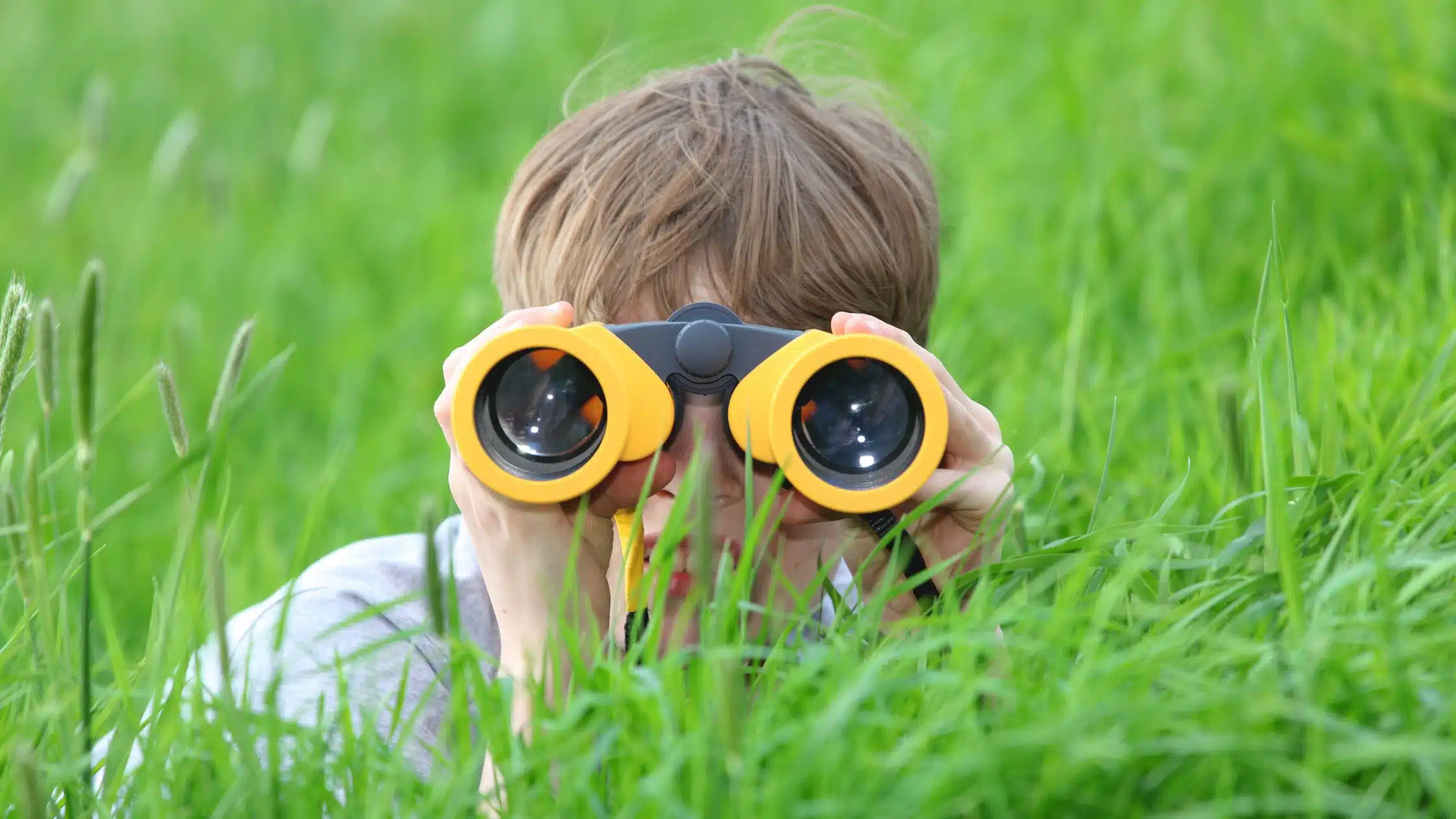 Little boy spying through binoculars